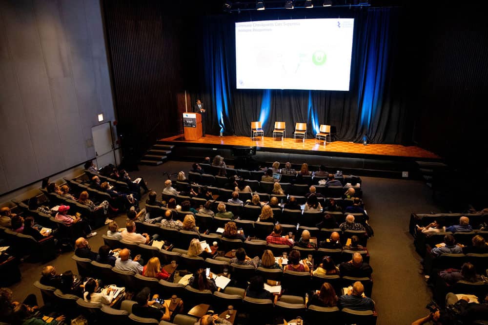 Dr. Vamsi Velcheti explains during his immunotherapy basics presentation how blocking a pathway on an immune cell can help activate the immune system to fight and eliminate cancer. Photo by Hannah Cohen.