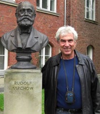 Michael Karin posing with a bust of Rudolf Virchow