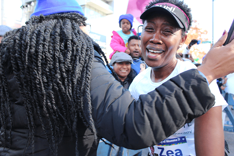 Zea McKenzie embraces family at the 8 Mile mark at the 2018 NYC Marathon
