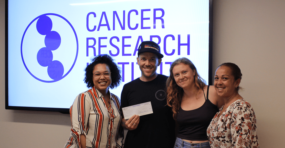 Brian delivers his check to the Cancer Research Institute