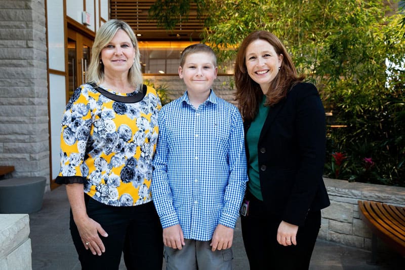 14-year-old Cole Malone (center) with his mom, Denise Malone (left), and one of his oncologists, DFCI’s Dr. Susanne Baumeister (right). Photo by Adrianne Mathiowetz.