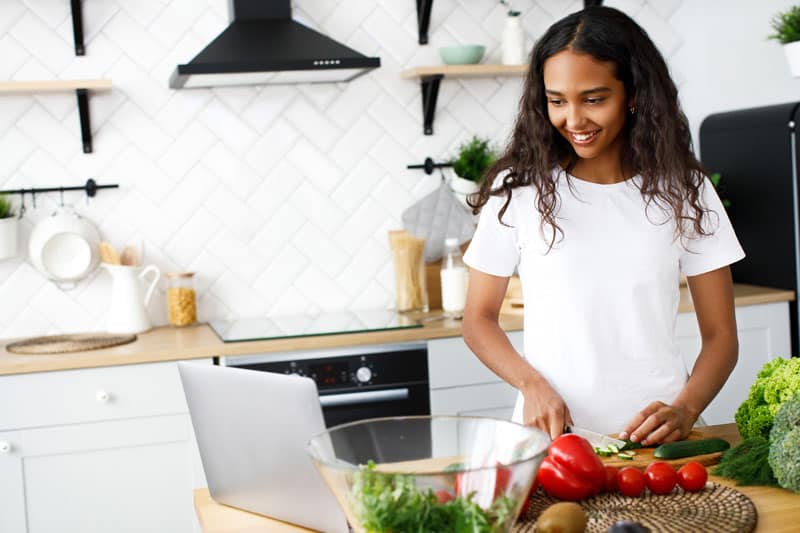 Young girl cooking with tablet