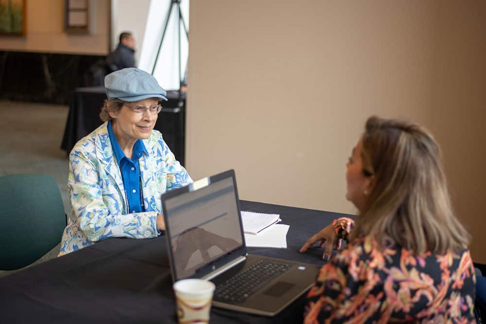 Summit attendee meets with a clinical trial navigator. Photo by Ranjani Groth.