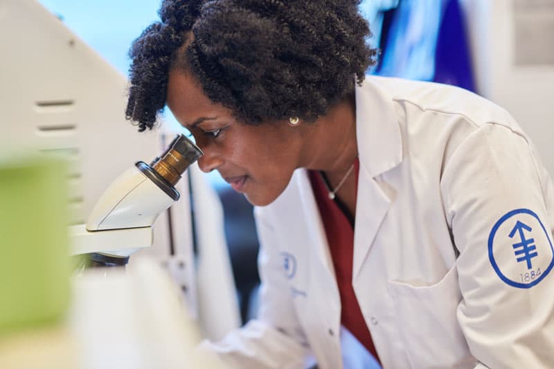 Dr. Melody Smith (MSKCC) with microscope in the lab of Dr. van der Brink