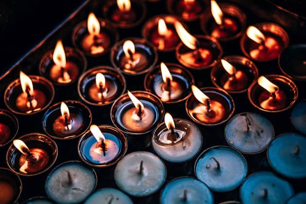 A group of memorial candles. Some are burning and some are not.