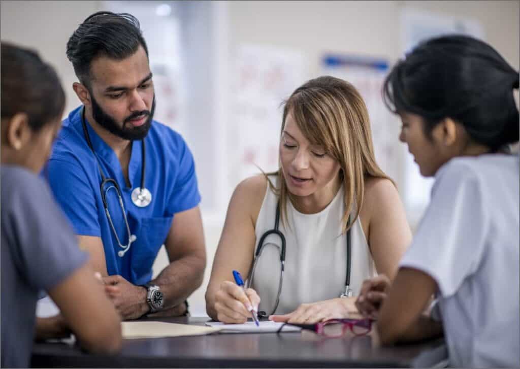 A group of medical personal meet around a table