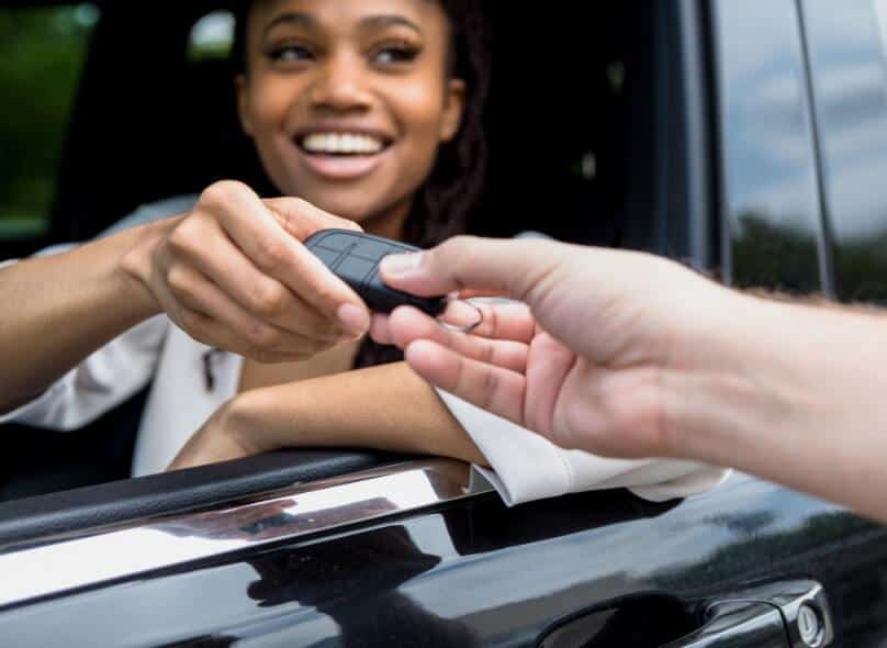 Person exchanges a car fob with another person through a car window